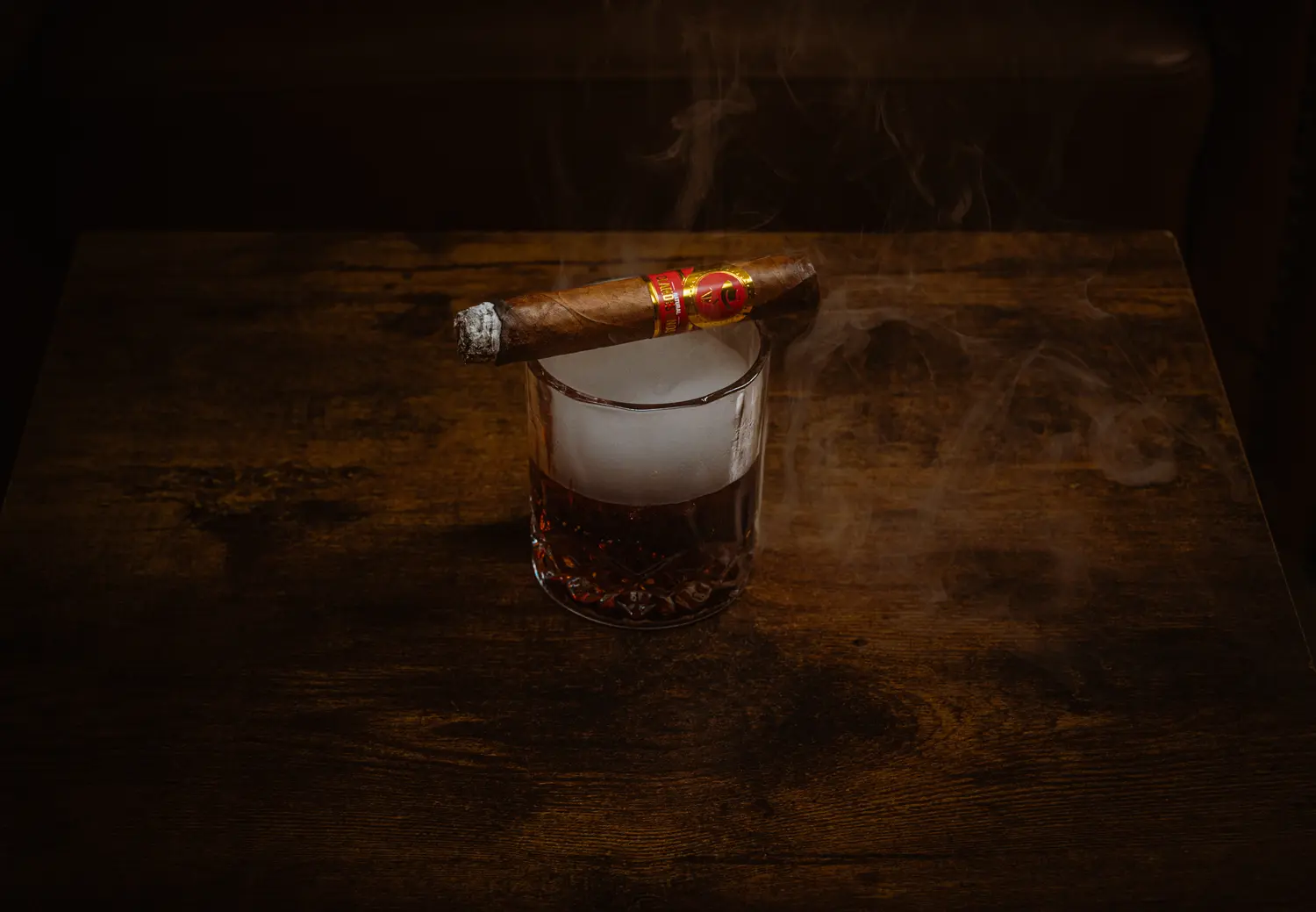 Un puro sobre un vaso de whisky